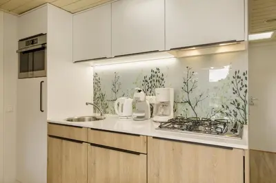a kitchen with white cabinets and a counter top at Center Parcs De Eemhof in Zeewolde