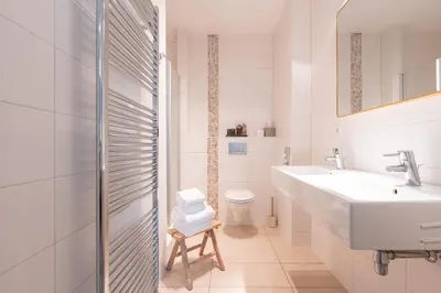 a white bathroom with a sink and a toilet at Hotel het Oude Raadhuis in Castricum
