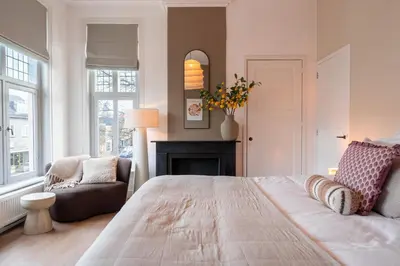 a bedroom with a large bed and a fireplace at Hotel het Oude Raadhuis in Castricum