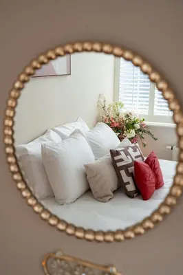 a mirror reflecting a bed with white pillows at Hotel het Oude Raadhuis in Castricum