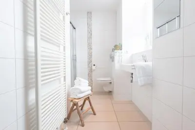 a bathroom with a toilet and a stool with towels at Hotel het Oude Raadhuis in Castricum