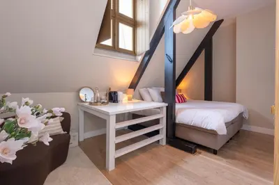 a room with a bed and a desk with a table at Hotel het Oude Raadhuis in Castricum