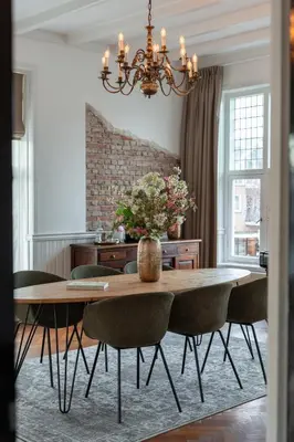 a dining room with a table with chairs and a chandelier at Hotel het Oude Raadhuis in Castricum
