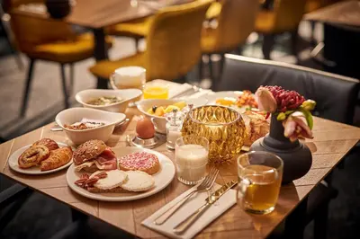 a wooden table with plates of food on it at Van der Valk Hotel Amsterdam - Amstel in Amsterdam