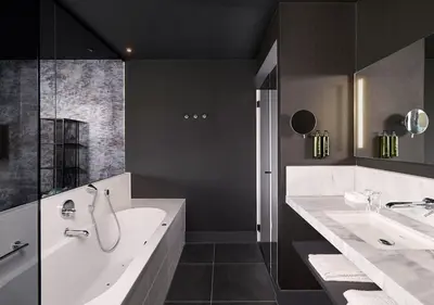 a bathroom with two sinks and a tub and a shower at Van der Valk Hotel Amsterdam - Amstel in Amsterdam