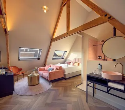 a bedroom with a bed and a bathroom with a sink at The Anthony in Utrecht