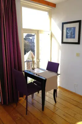 a table and chairs in a room with a window at Studio Eelhouse in Amsterdam