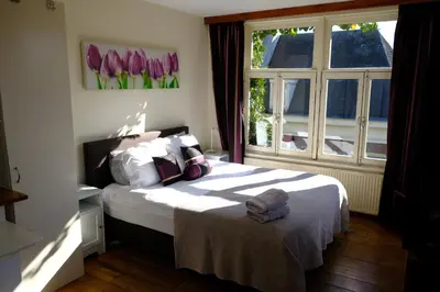 a bedroom with a large bed and a window at Studio Eelhouse in Amsterdam