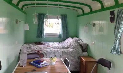 a small bedroom with a bed and a table at Bed & Breakfast ARKEN AE in Zuiderwoude