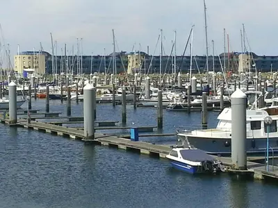 a boat docked at a marina with other boats at Chalet Dalile IJmuiden aan Zee vlakbij het strand in IJmuiden