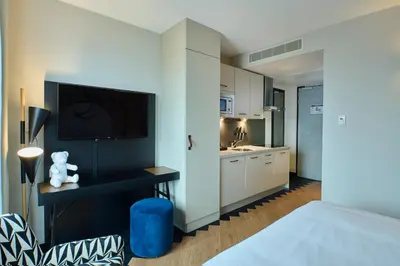 a bedroom with a bed and a tv on a wall at Cityden Stadshart in Amstelveen