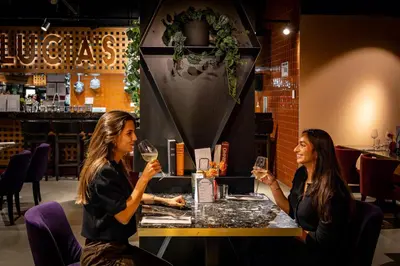 two women sitting at a table with wine glasses at Cityden Stadshart in Amstelveen