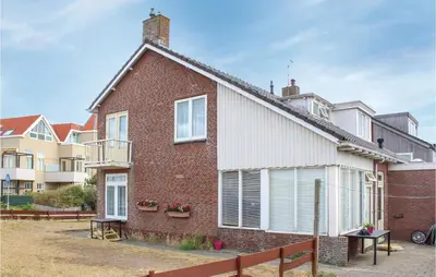 a red brick house with a white roof at De Vissende Beer in Egmond aan Zee