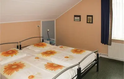 a bedroom with two beds with flowers on them at De Vissende Beer in Egmond aan Zee