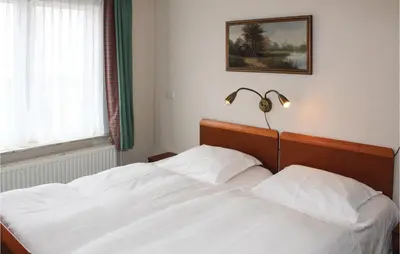 a bedroom with a white bed with a lamp on it at De Vissende Beer in Egmond aan Zee