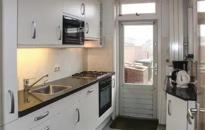 a kitchen with a sink and a stove top oven at De Vissende Beer in Egmond aan Zee