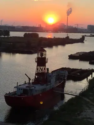 a boat in the water with the sunset in the background at Studio Black Jack in Amsterdam