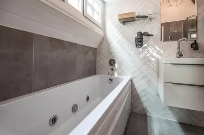 a white bathroom with a tub and a sink at Boutique Hotel Huys van Leyden in Leiden