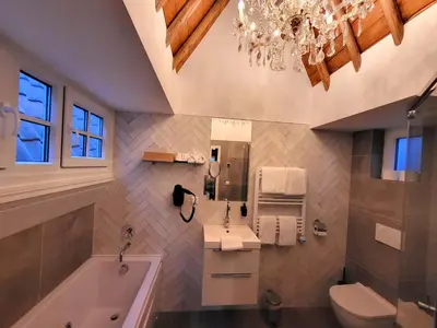 a bathroom with a tub and a sink and a toilet at Boutique Hotel Huys van Leyden in Leiden