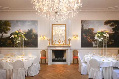 a dining room with white tables and a chandelier at Boutique Hotel Huys van Leyden in Leiden