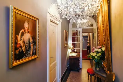 a hallway with a painting and a vase of flowers at Boutique Hotel Huys van Leyden in Leiden