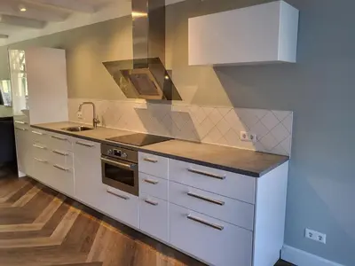 a kitchen with white cabinets and a sink at Boutique Hotel Huys van Leyden in Leiden