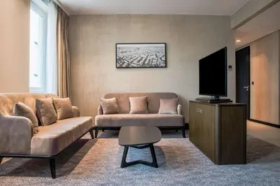 a living room with two couches and a flat screen tv at Radisson Hotel & Suites Amsterdam South in Amstelveen