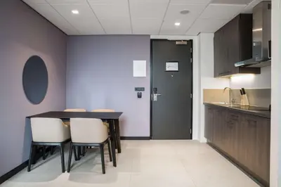 a kitchen with a table and chairs and a door at Radisson Hotel & Suites Amsterdam South in Amstelveen