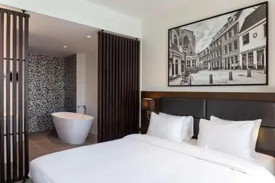 a bedroom with a bed and a bath tub and a sink at Radisson Hotel & Suites Amsterdam South in Amstelveen