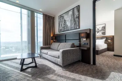 a living room with a couch and a bed at Radisson Hotel & Suites Amsterdam South in Amstelveen