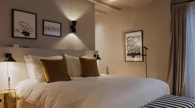 a bedroom with a bed with white sheets and yellow pillows at Suite no 7, hidden gem center of Amsterdam in Amsterdam