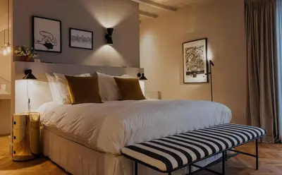 a bedroom with a large bed with a bench next to it at Suite no 7, hidden gem center of Amsterdam in Amsterdam