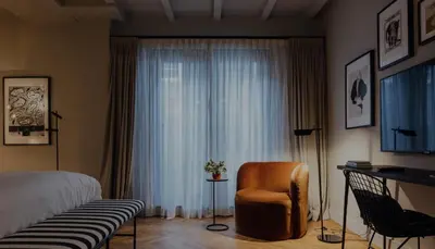 a bedroom with a bed and a chair and a window at Suite no 7, hidden gem center of Amsterdam in Amsterdam