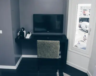 a living room with a tv and a chair at Canal House Inn in Amsterdam