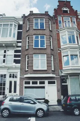 a blue car parked in front of a building at Canal House Inn in Amsterdam