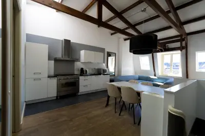 a kitchen with white cabinets and a table with chairs at Plantage Hortus Apartments in Amsterdam