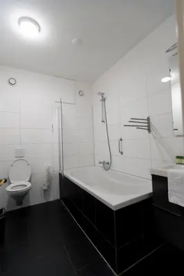 a white bathroom with a tub and a toilet at Plantage Hortus Apartments in Amsterdam