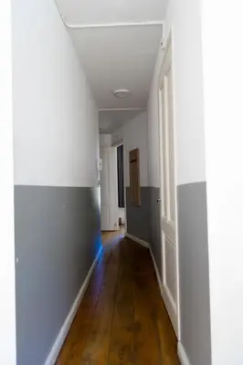 an empty hallway with white walls and wood floors at Plantage Hortus Apartments in Amsterdam