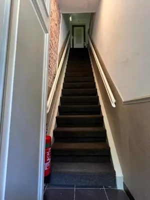 a hallway with stairs leading up to a door at Plantage Hortus Apartments in Amsterdam