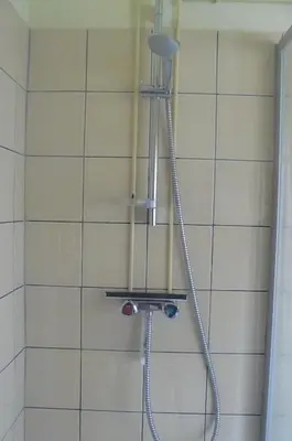 a shower in a bathroom with a shower head at Amsterdam Beach Apartment in Zandvoort