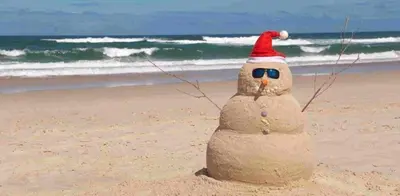 a sand sculpture of a snowman with a santa hat on the beach at Amsterdam Beach Apartment in Zandvoort