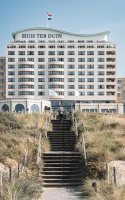 a building with stairs in front of a building at Grand Hotel Huis ter Duin in Noordwijk aan Zee