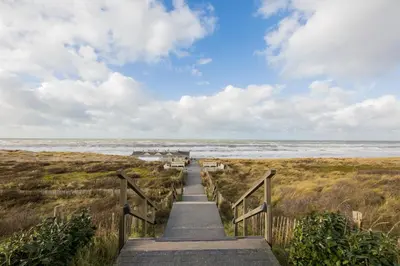 a stairway leading down to a beach with the ocean at Grand Hotel Huis ter Duin in Noordwijk aan Zee