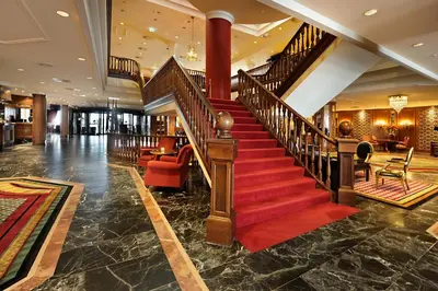 a staircase in a lobby with a red carpet at Grand Hotel Huis ter Duin in Noordwijk aan Zee