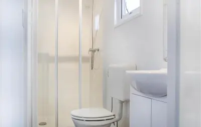 a white bathroom with a toilet and a sink at Markermeerzicht in Bovenkarspel