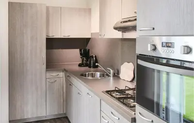 a kitchen with a sink and a stove top oven at Markermeerzicht in Bovenkarspel