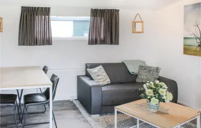 a living room with a couch and a table at Markermeerzicht in Bovenkarspel