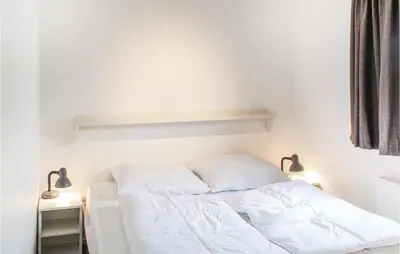 a white bed with two pillows on it in a room at Markermeerzicht in Bovenkarspel