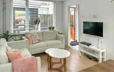 a living room with a couch and a tv at Dophuisje in Egmond aan Zee