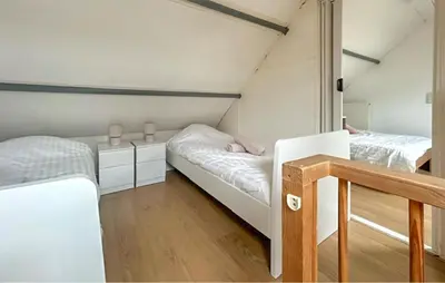 two beds in a small room with white walls at Dophuisje in Egmond aan Zee